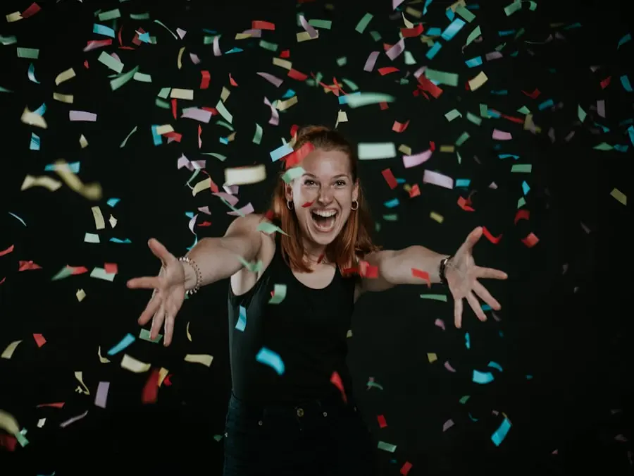 A guest laughing with open arms in a shower of confetti