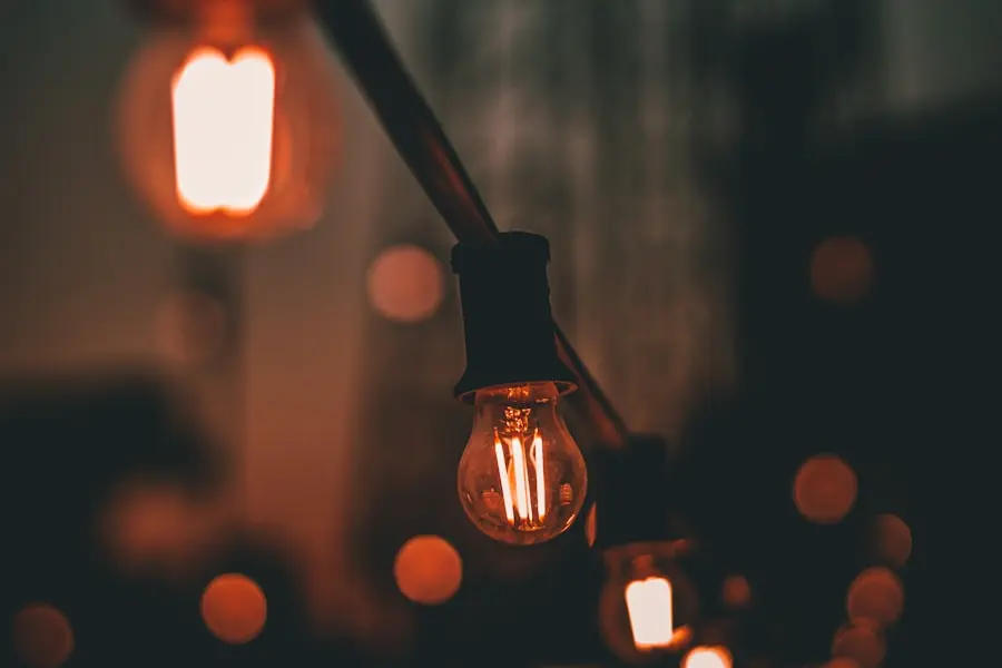 A warm string-light bulb glowing at dusk